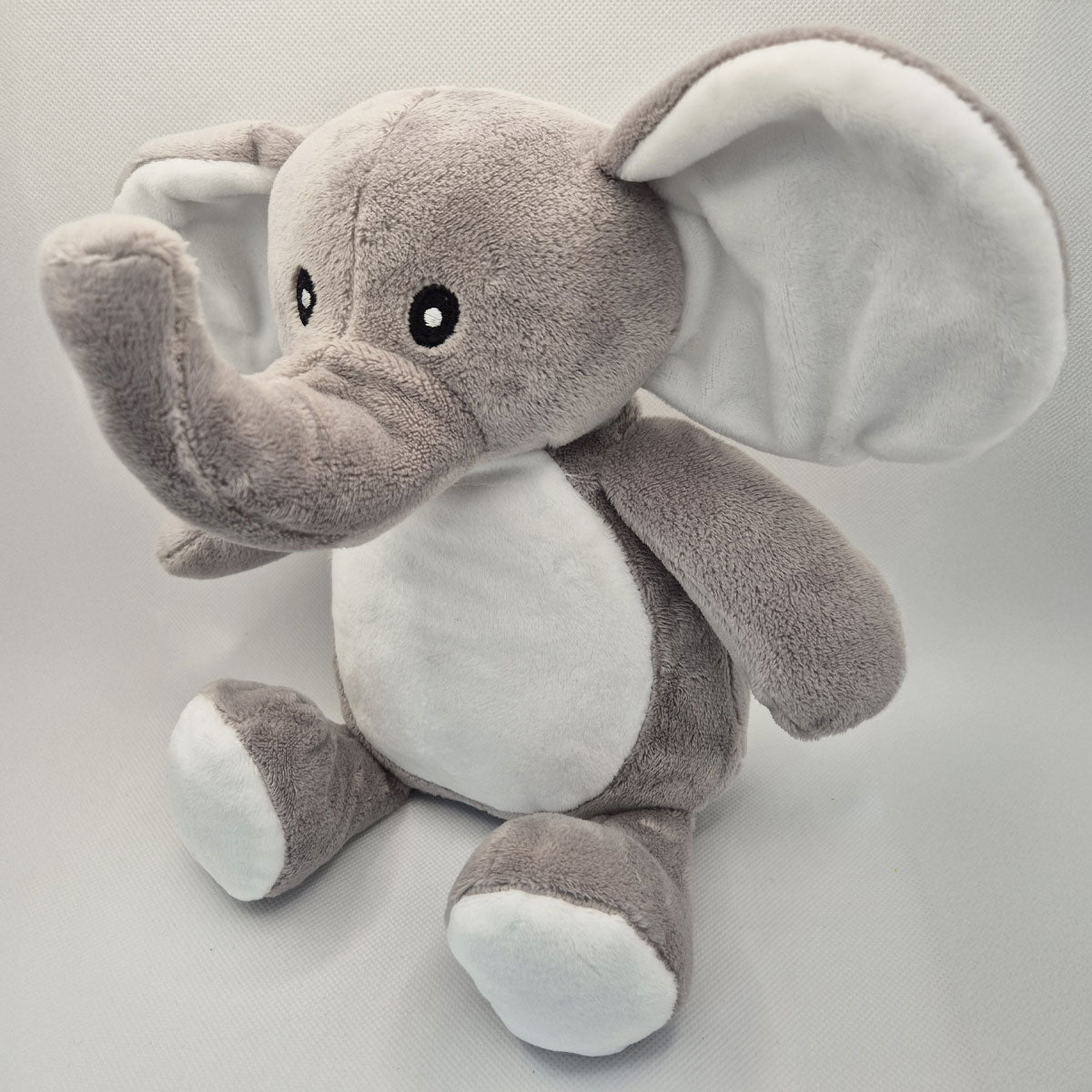 Side view of an elephant teddy toy on a light grey background