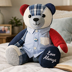Stuffed teddy bear with a shirt and scarf on a bed