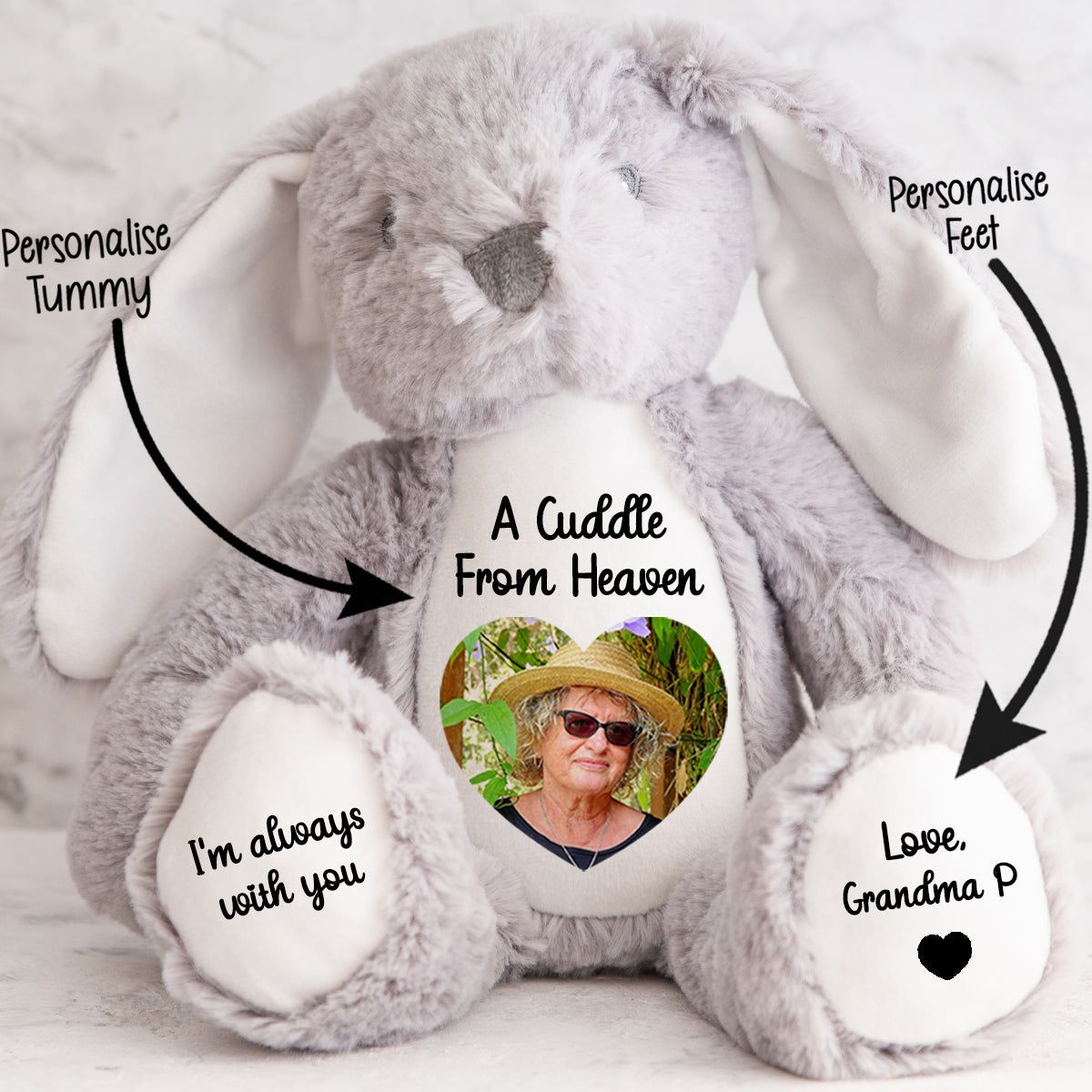 Gray stuffed bunny with customisable cuddle from heaven text and a heart shaped photo on a light background. CFHGBU