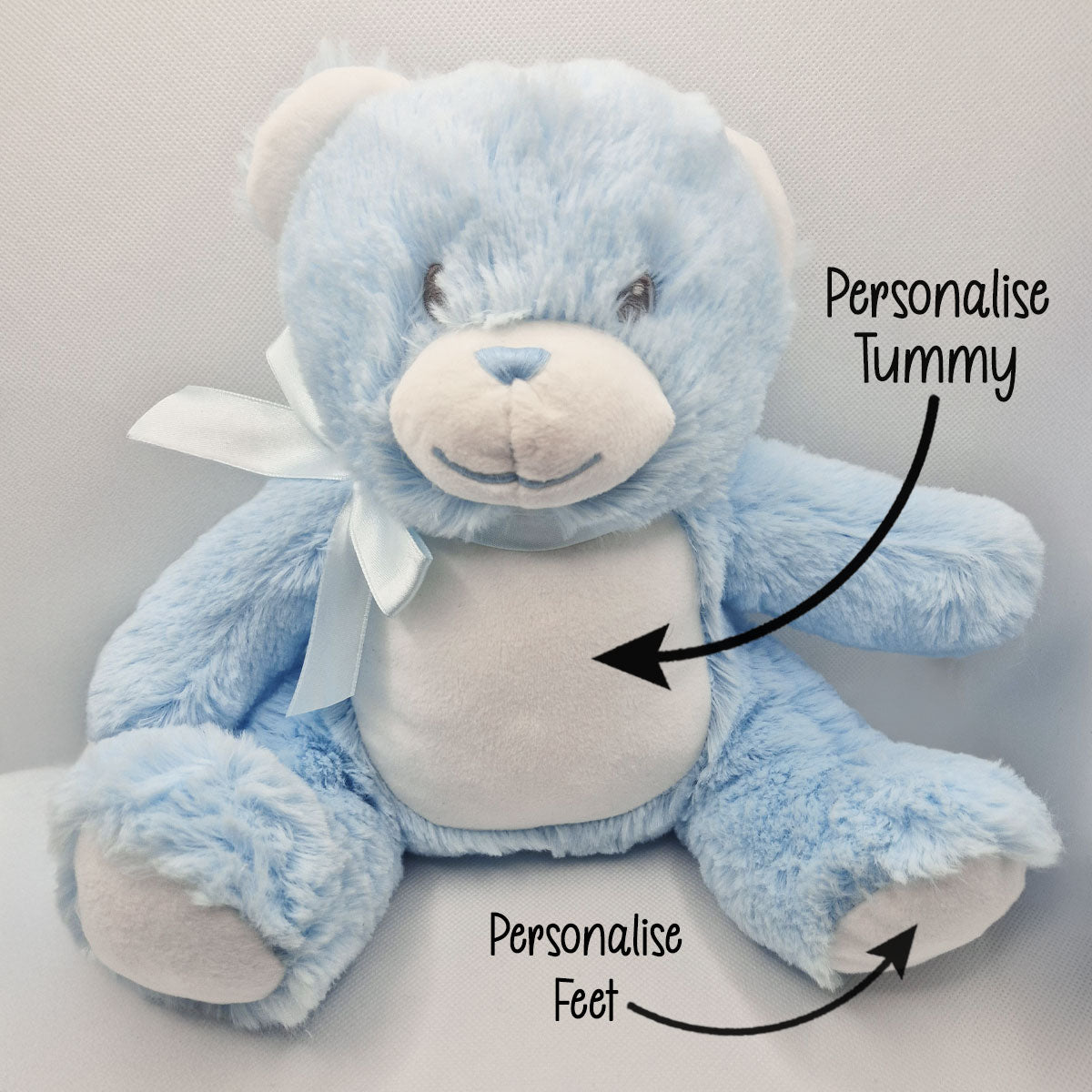 Blue teddy bear with text indicating areas to personalise on a light gray background