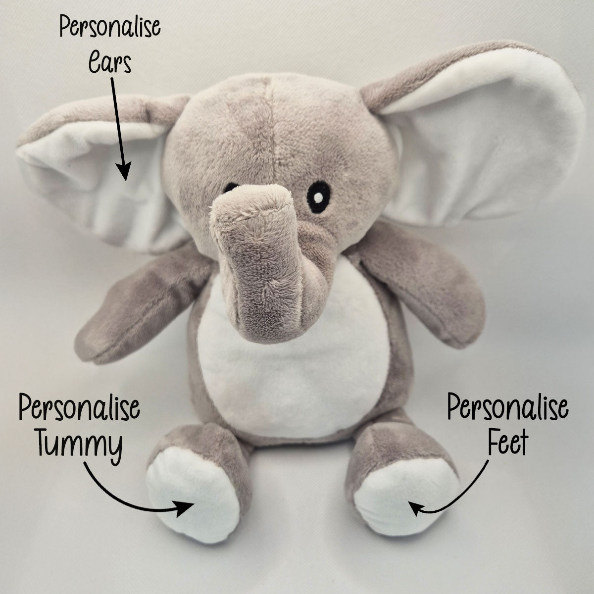 Plush elephant toy with text indicating areas to personalise on a light gray background