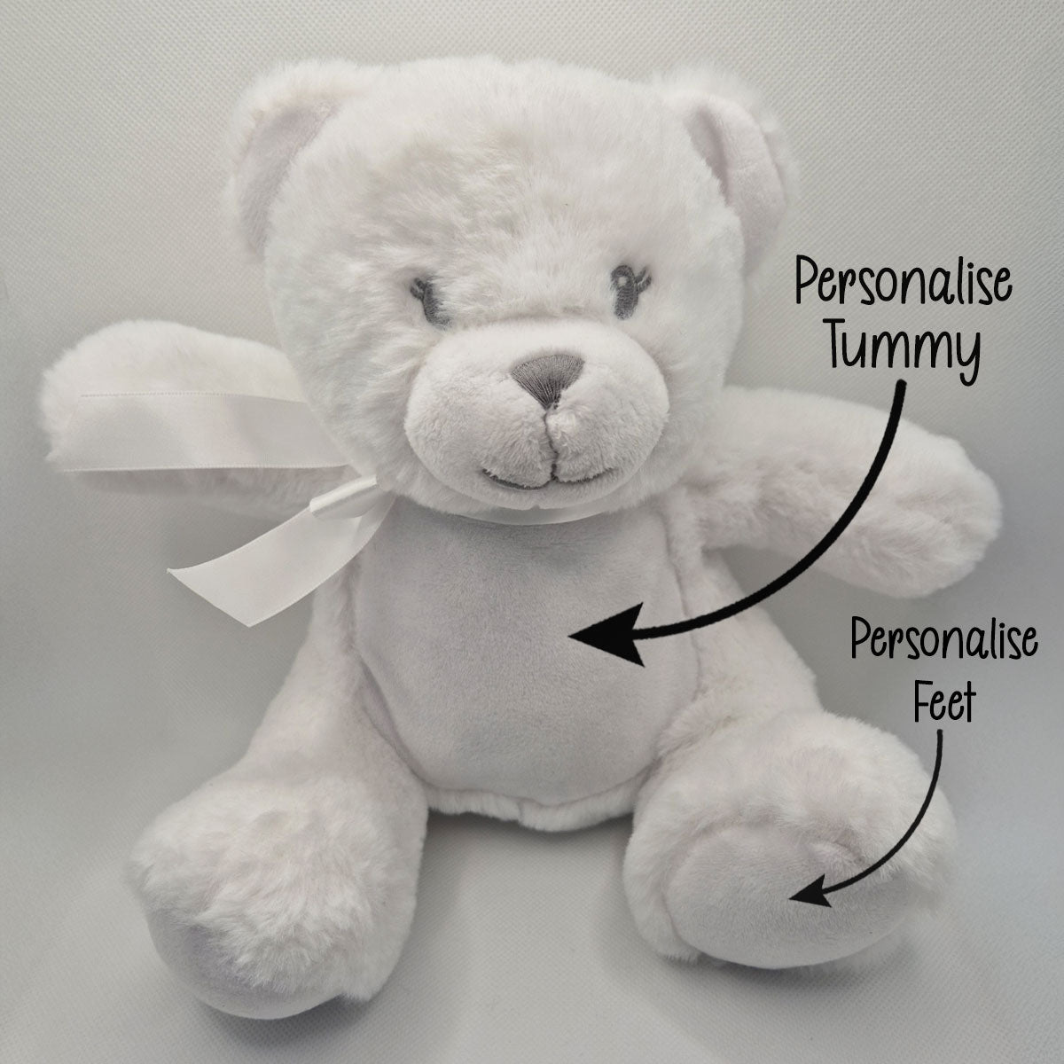White teddy bear with text indicating areas to personalise on a light gray background