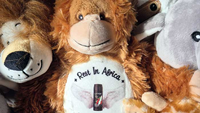 Plush toy lion with a bottle of Jagermeister and 'Rest In Africa' text, surrounded by other plush toys.